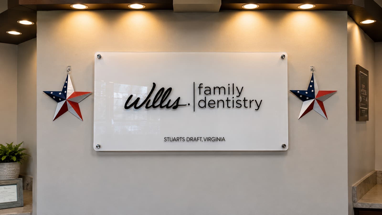 Willis & Associates Family Dentistry lobby sign in Stuarts Draft, Virginia, flanked by two American-flag stars